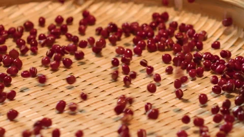 Close-up of Red Adzuki Beans Scattered on Woven Bamboo Mat Stock-Footage 335498661
