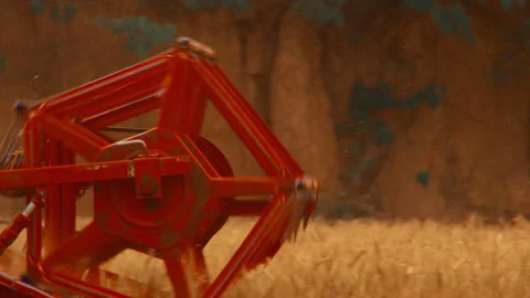 Close-up Red Agricultural Harvester Header Cutting Through Dusty Field Stockbeeldmateriaal 335476885