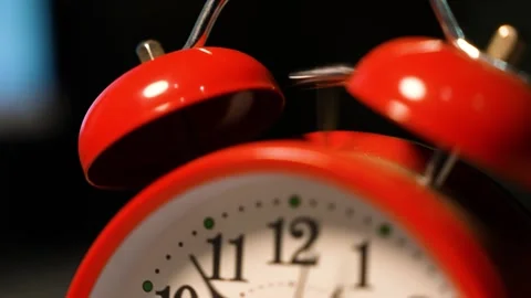 Close-up of a red alarm clock with a classic design, featuring two bells on.. Stock Footage 321936957