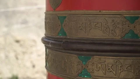 Close-up of a red and gold buddhist prayer wheel with Tibetan script 動画素材 309330703
