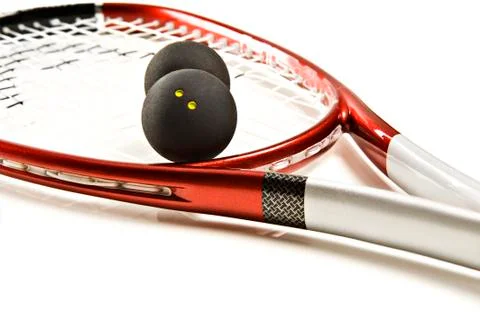 Close up of a red and silver squash racket and ball on a white background wit Stock Photos