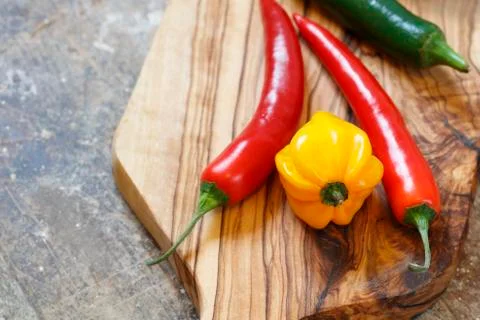 Close up of red and yellow hot peppers on cutting board Stock Photos