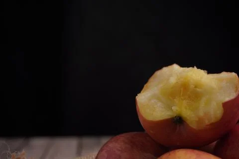 Close up red apple bites on black background Stock Photos