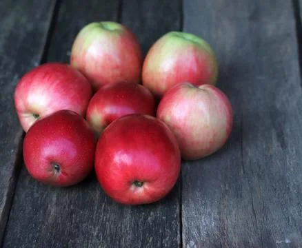 Close-up of red apples on the background of an old board. Stock Photos