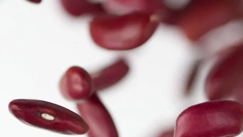 Close up red beans flies in slow motion on the white background Video stock 148552510