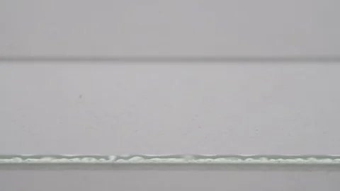 A close-up of a red blood drop dropping from a pipette onto laboratory slide Stock Footage 110287220