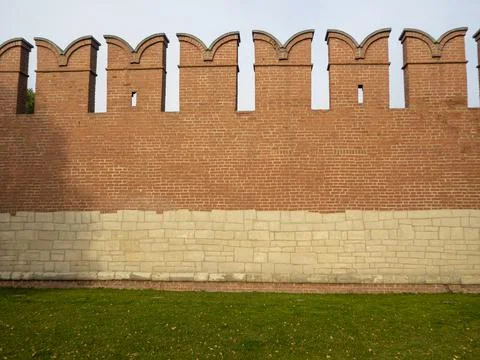 Close-up of red brick Kremlin wall. Green grass under the wall Stock Photos