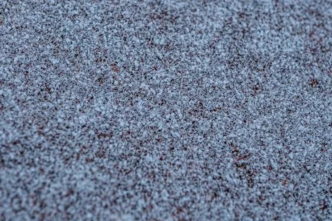 A close-up of red brick tiles lightly covered in frost or snow, creating. Fotos de archivo