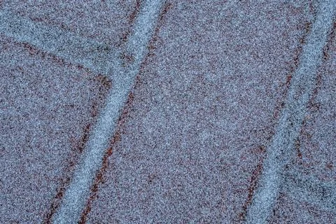 A close-up of red brick tiles lightly covered in frost or snow, creating. Fotos de archivo