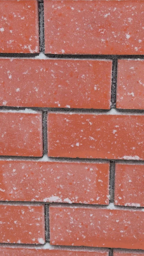 A Close-up of a red brick wall dusted with white snow Stock Footage 325962411