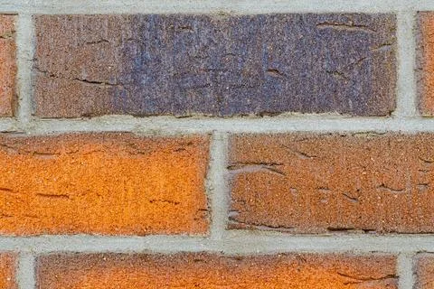 Close-up of red brick wall with one dark contrasting brick. 写真素材