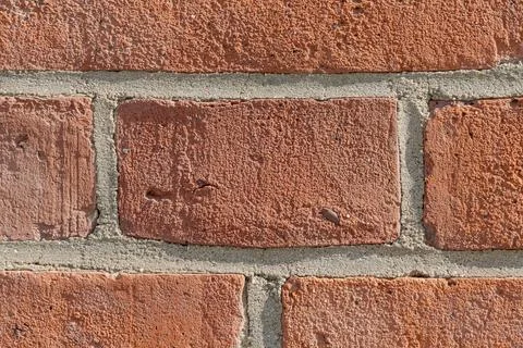 Close-up of red brick wall with rough porous surface and mortar joints 스톡 사진