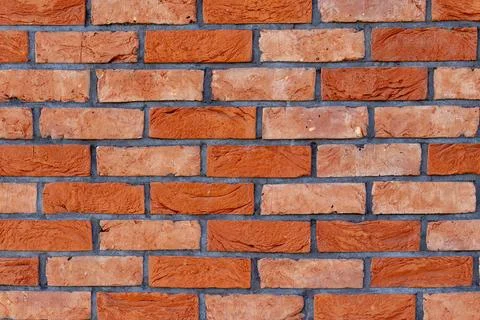 Close-up of a red brick wall with textured surface and dark mortar lines, c.. Stock Photos