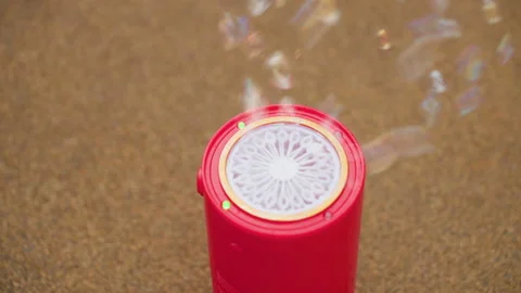Close Up Red Bubble Machine on Pavement Releasing Bubbles 動画素材 321479020