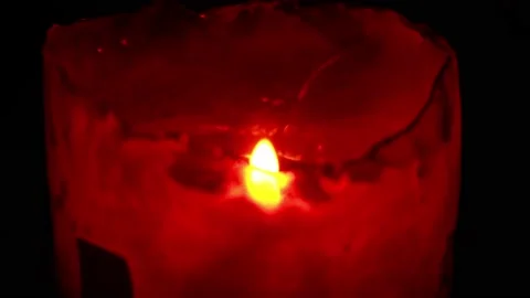Close-up of a red candle in the dark of a restaurant at night Stock Footage 164572025