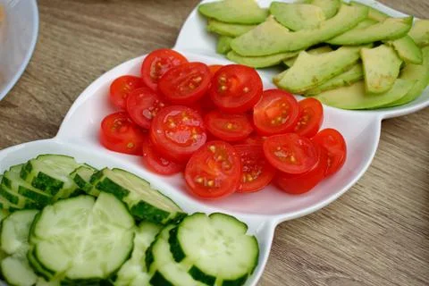 Close-up of red cherry tomatoes sliced on a white plate. Stock-Fotos