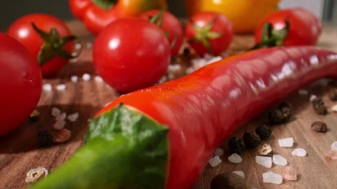 Close up red chili pepper lying on wooden cutting board with tomatoes Stock Footage 304489181
