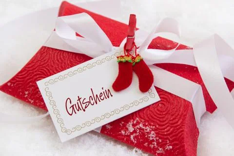 Close up of red christmas present box with german text for a coupon Stock Photos
