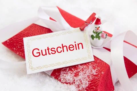 Close up of red christmas present box with german text for a coupon Stock Photos