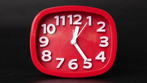 Close-up of red clock time lapse on black background. A red wall clock running Stock Footage 261256906