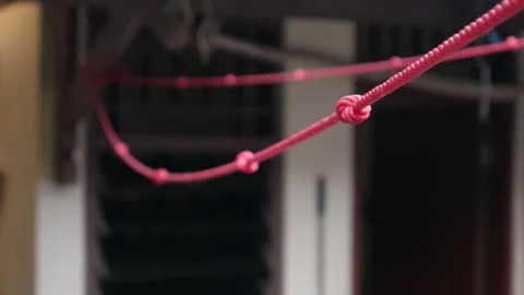 Close-Up of Red Clothesline Rope with Knots and Blurred Background. Stock Footage 336983530