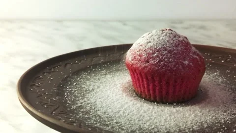 Close-up of a red cupcake on a clay plate spinning on a white background Video stock 231076406