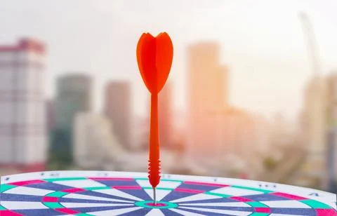Close-up red dart arrow hitting in target center of dartboard Business goal.. 스톡 사진