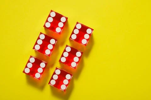 Close-up of a red dices on a yellow table Foto stock