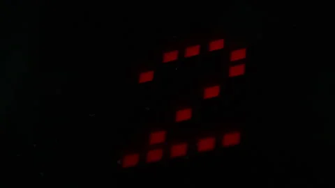 Close up of red digital display showing countdown from one to four in dark Stock Footage 341011304