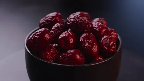 Close-up of Red Dried Jujubes Overflowing from Matte Black Bowl Video stock 336560241