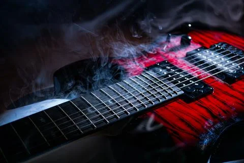 Close-up of a red electric guitar on a surface, illuminated from below, showc 스톡 사진