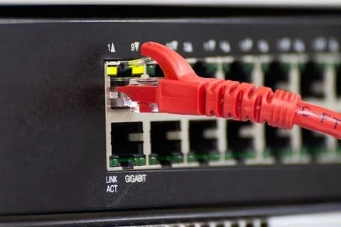 Close-up a red ethernet cable into a network switch or router Stock Photos