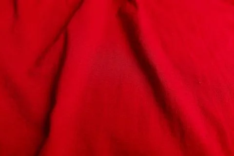 Close-up of red fabric texture with soft vertical folds and fine weave detail Stock Photos