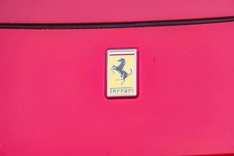 Close-up of red Ferrari side panel featuring a prominent prancing horse emble 写真素材