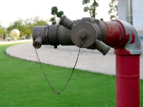 Close-up red fire hydrant spigot for connecting the fire hose in the lawn. Stock Photos