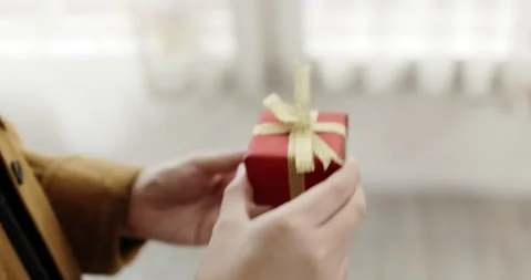 Close Up Red gift box with golden ribbon giving to lover at hand. Surprise gift  Stock Footage 165607283