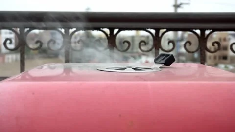 Close-up of a red grill blowing smoke above its grates heating up to cook meat Stock Footage 160087598