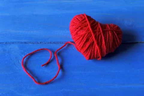 Close up of Red heart shape made from thread yarn on blue wooden for Valent.. Stock Photos
