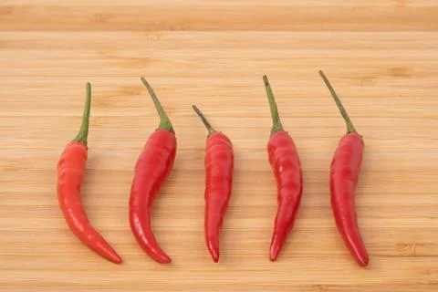 Close up red hot chilli pepper on wood chopping board. Stock Photos