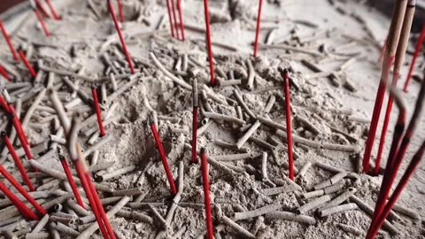 Close-up of red incense sticks with ash in a sandy base selective focus Stock Footage 345332956