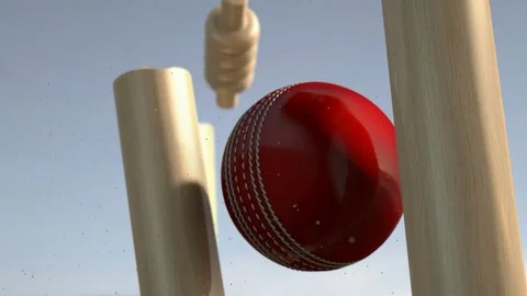A close up of a red leather stitched cricket ball hitting wooden wickets Stock Footage 72225155