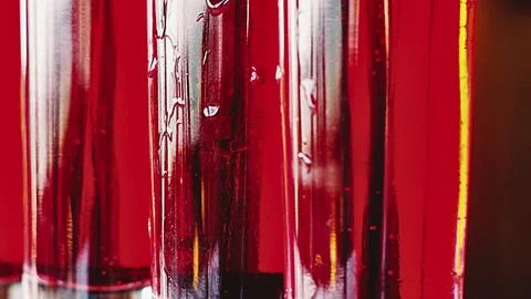 Close up of red liquid in clear test tubes abstract background Stock Photos