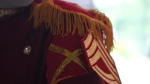 Close up of red marching band uniform with golden epaulet fringe  Video stock 337872094