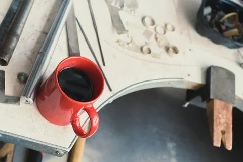 Close up red mug with coffee placing on workshop table concept photo Stock Photos