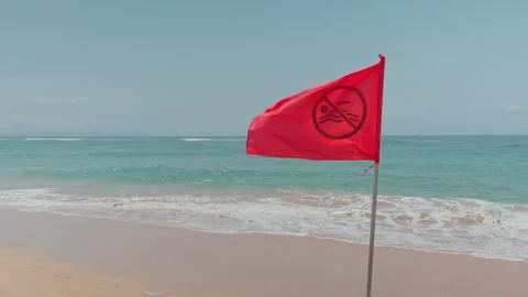 Close red no-swimming flag by waves , Nusa Dua, Bali 库存影片 336515196