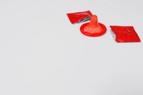 Close up of red open condom on white background Stock Photos