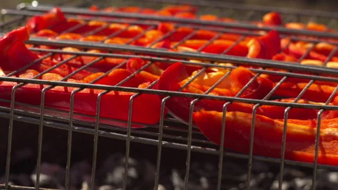 Close-up of red pepper slices in stainless mesh grill, light smoke, spring light Stock-Footage 332558881