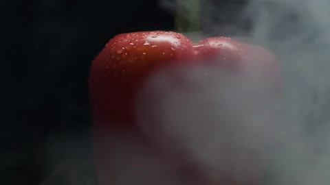 Close-up of a red pepper in smoke on a black background. Stock Footage 300678236