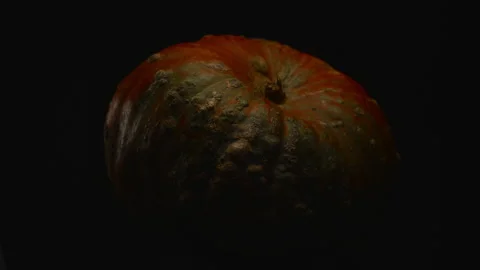 Close-up, red pumpkin on a black background in a turning motion Stock Footage 185644673
