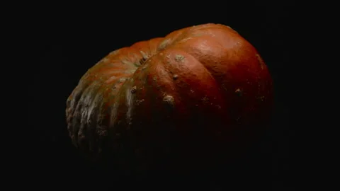 Close-up, red pumpkin in turning motion on a black background Stock Footage 178539271